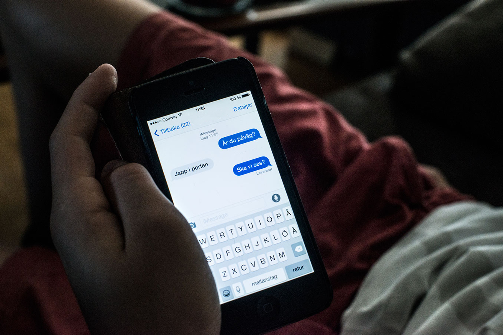 Händer som håller en mobil med ett meddelande.