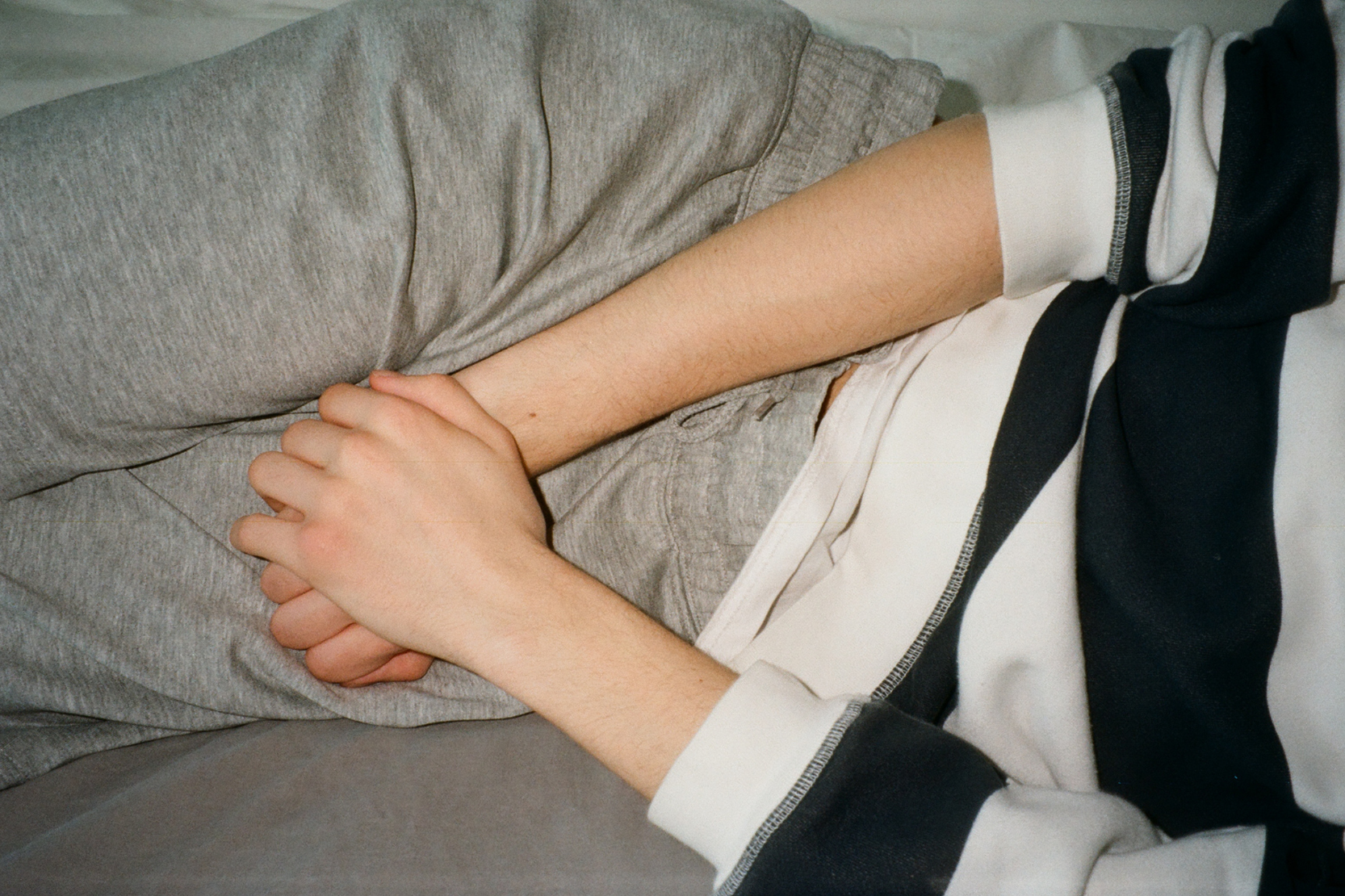 Person som håller handen ovanpå byxorna över könet, som att det gör ont där.