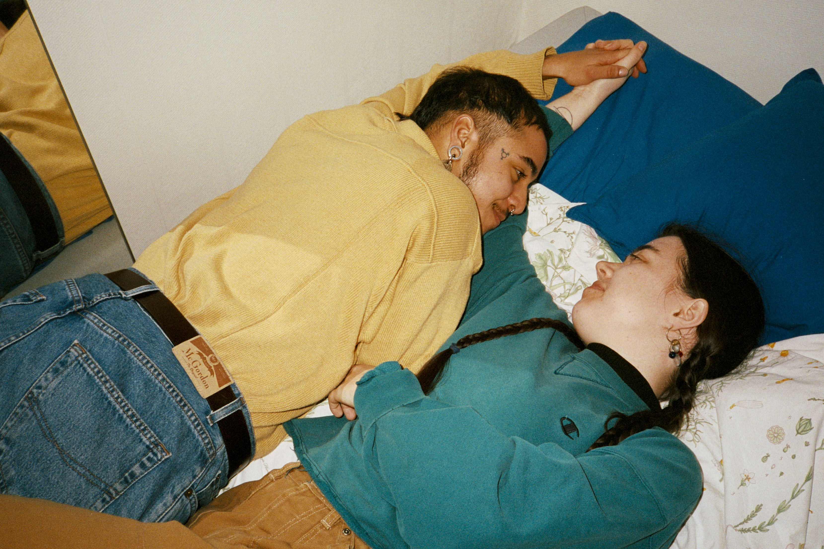 Två personer ligger i en säng och tittar kärleksfullt på varandra.
