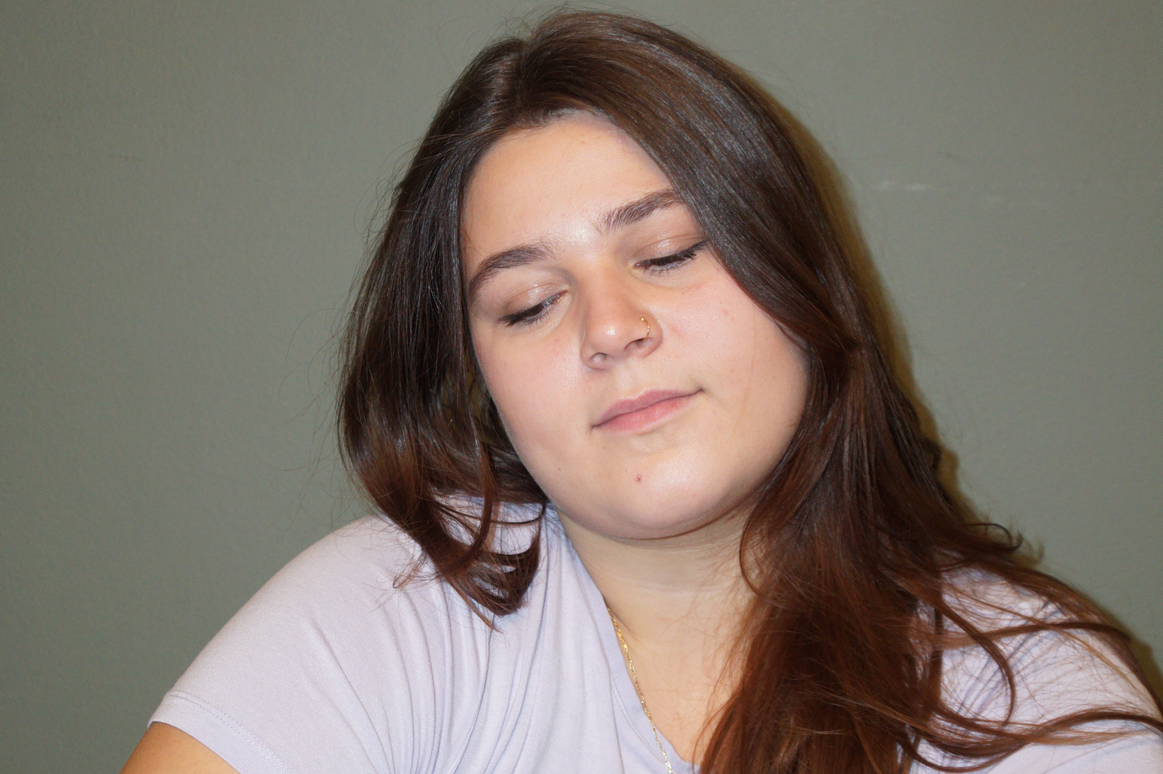 Tjej som ser  bekymrad ut med grå bakgrund