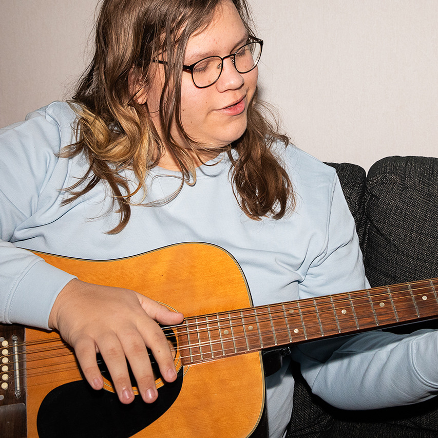 En person som spelar gitarr