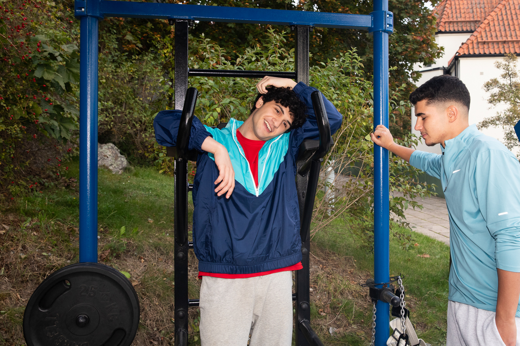 Två killar står vid ett utegym.